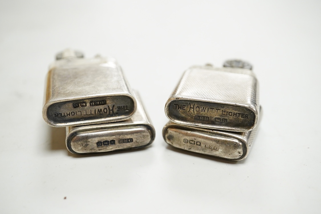 A near pair of George VI silver mounted lighters, each inscribed 'The Howitt Lighter', by Dudley Russell Howitt, Sheffield, 1946, (one engine turned), 58mm.